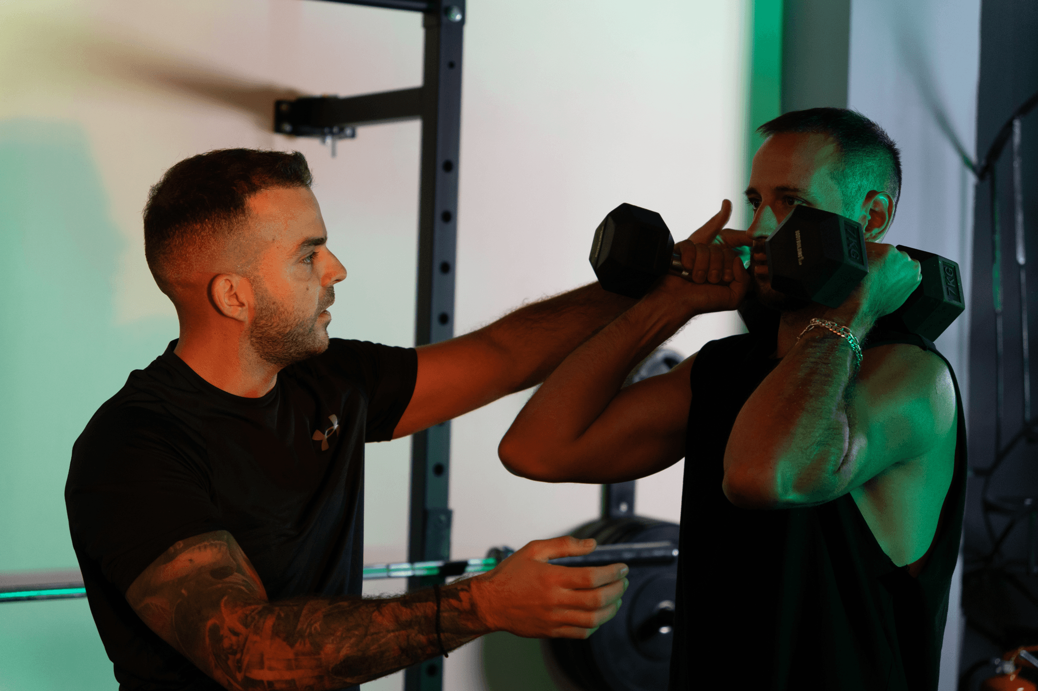 Personal trainer διορθώνει την τεχνική ασκούμενου με αλτήρες