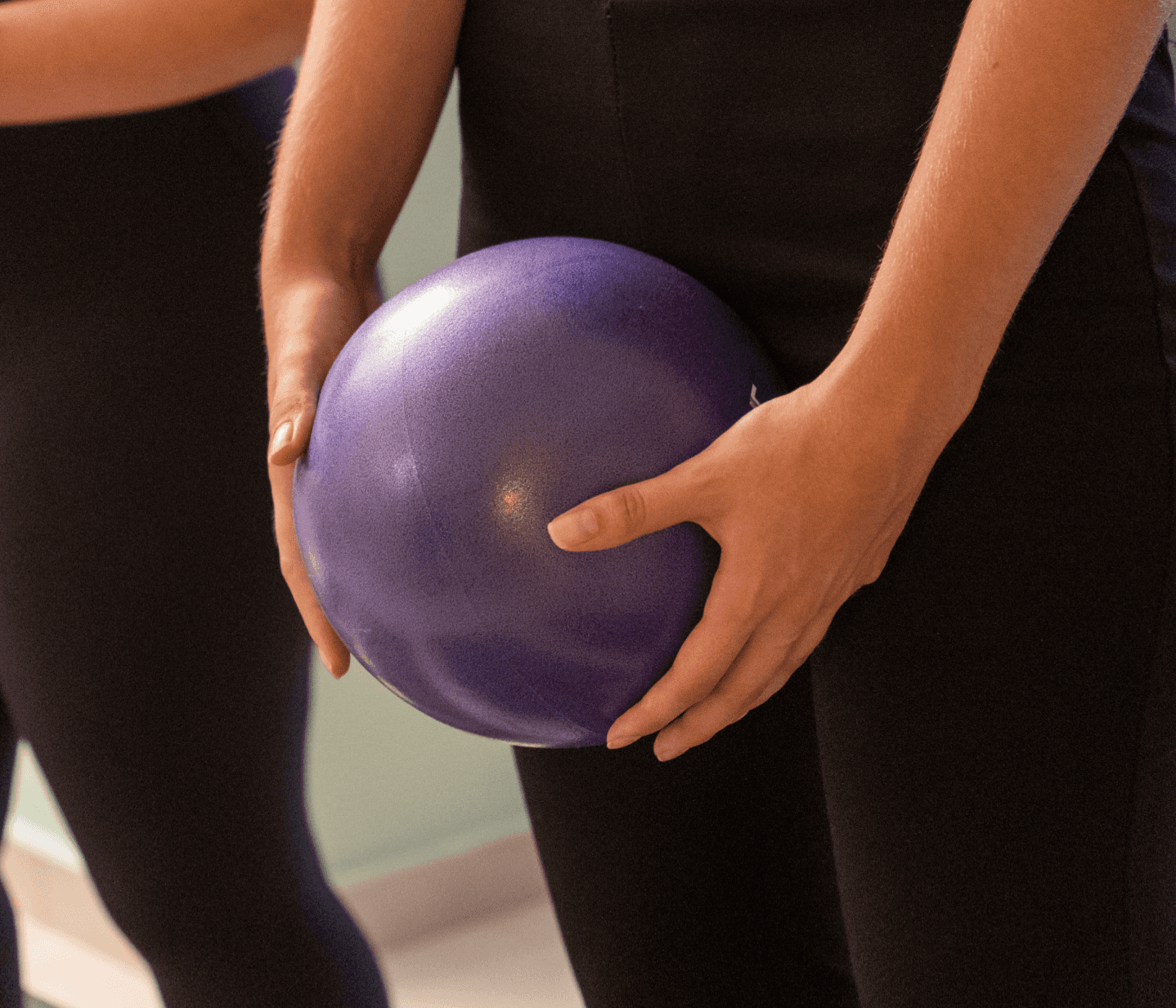 Αθλήτρια κρατά μικρή μπάλα Pilates