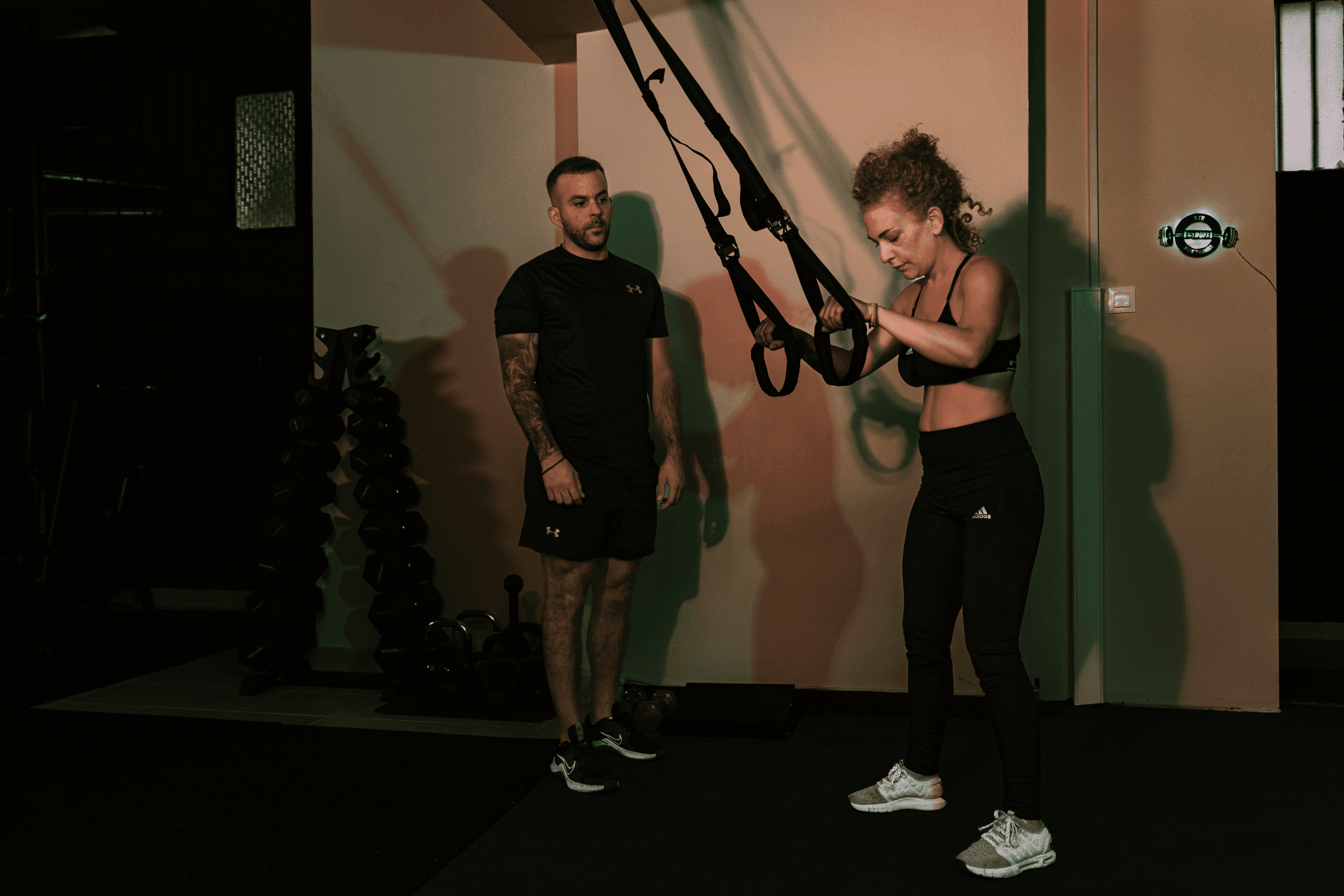 Trainer επιβλέπει άσκηση με ιμάντες TRX