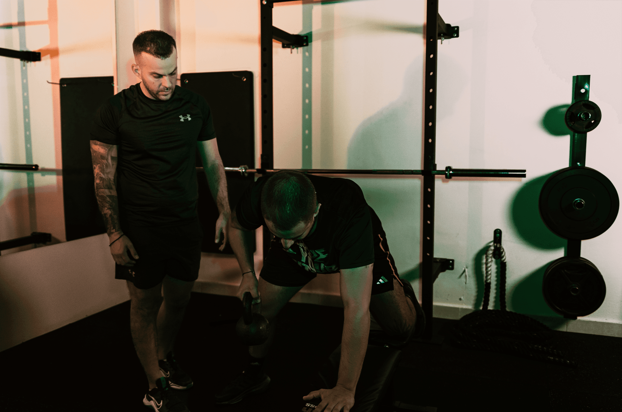 Trainer παρακολουθεί άσκηση με kettlebell